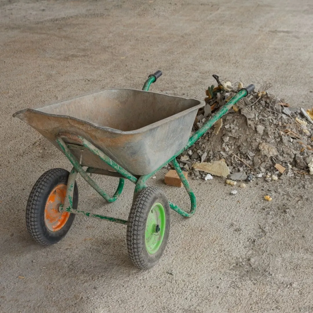 Wheelbarrow beside a pile of rubble and drywall scraps awaiting post-construction cleaning in Greenville, SC
